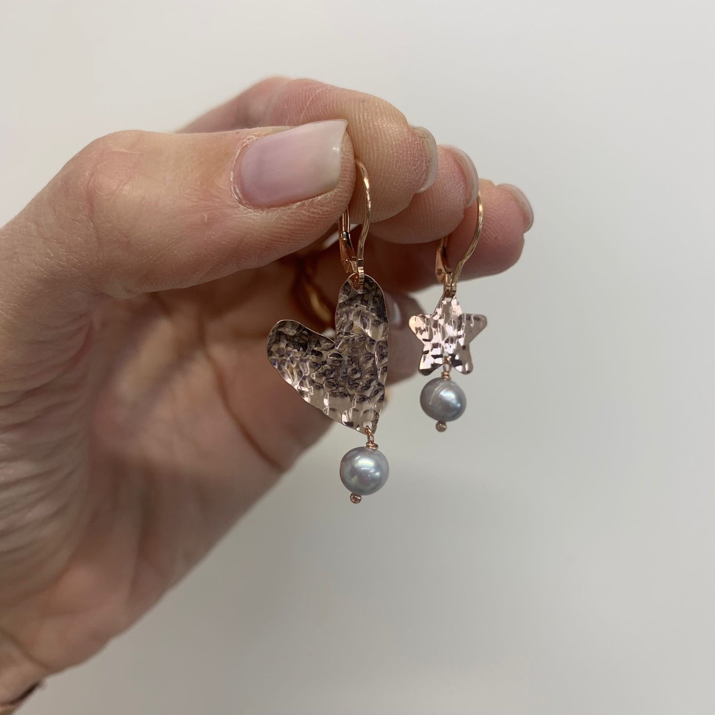 Coppia orecchini cuore allungato battuto da 2 cm con stella da 1.2 cm con perle grigie base rosè
