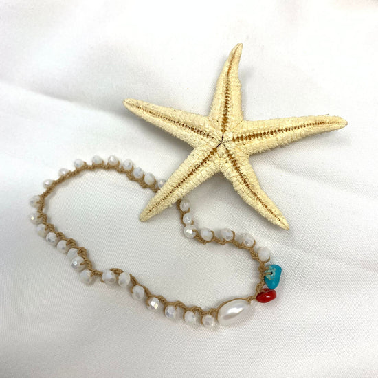 Cavigliera elastica con cristalli bianchi perla e pietre a forma di corallo