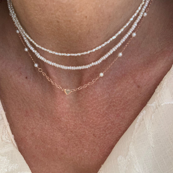 Collana catena rollò alternata da perle bianche cm 35 più 5 di allungamento con micro cuore rosè