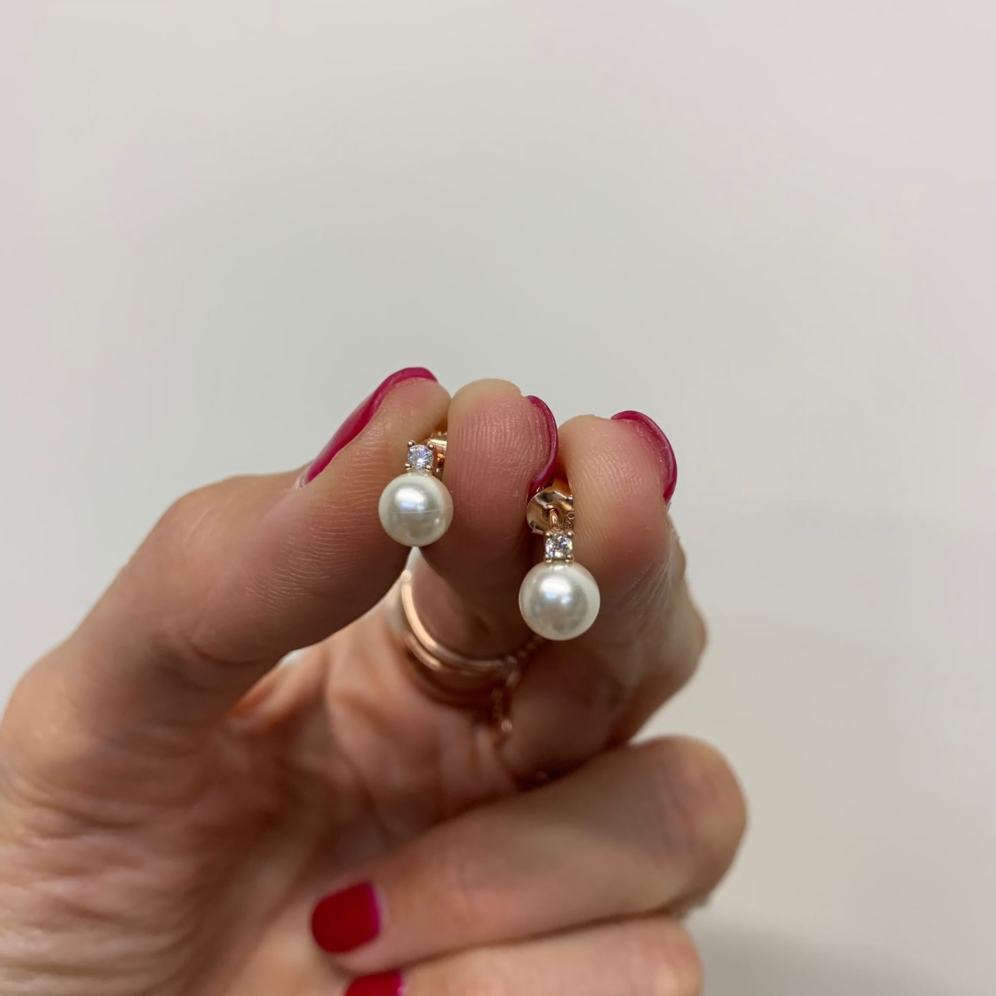 Coppia orecchini micro punto luce a lobo con perla tonda bianca diametro 0,5 mm rosé