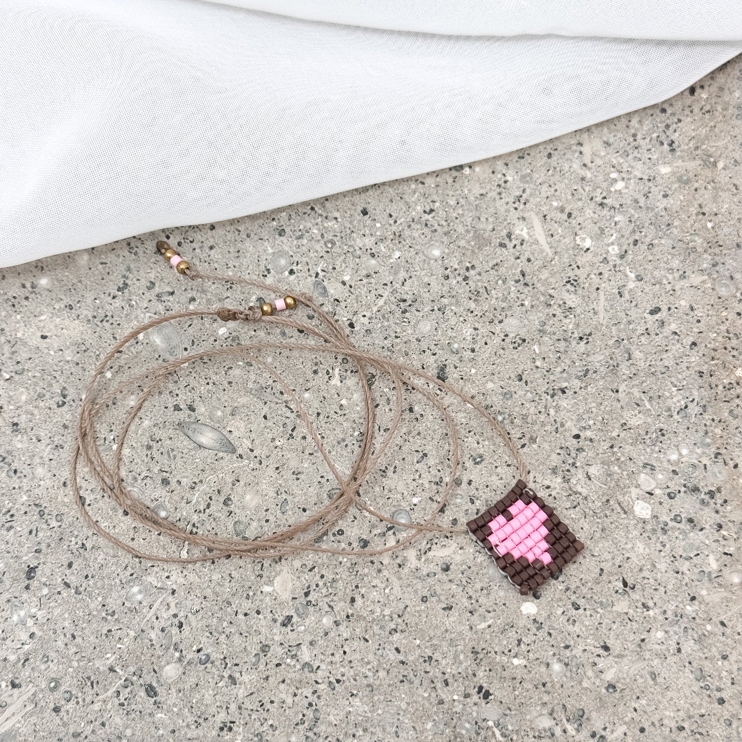 Collana regolabile Formentera con filo di seta e targhetta con cuore in perline rosa - Pezzo unico - Lumiere Bijoux