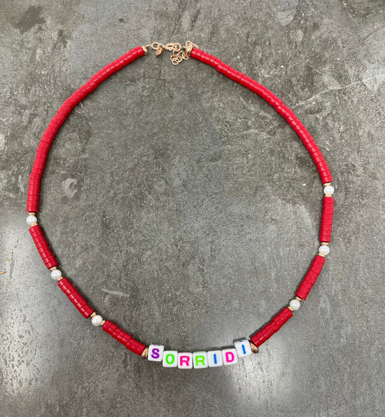 Collana rondelle colore rosso e perle con scritta colorata su cubetti “Sorridi” - cm 40