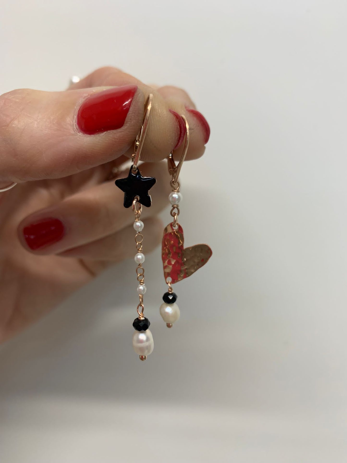 Coppia orecchini a monachella con stella nera allungo di micro perle e cuore allungato battuto grande con crue perla
